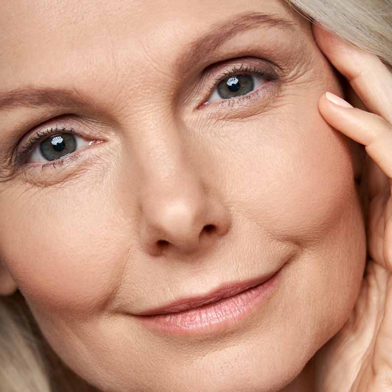 mujer-de-50-anos-mirando-la-camara-cuidado-de-la-piel-antiedad-vista-cercana-de-la-cara